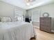 A neutral bedroom with a ceiling fan, two windows, and a wood dresser at 1734 Shore Acres Ne Blvd, St Petersburg, FL 33703