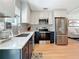 This updated kitchen features stainless steel appliances, patterned backsplash, and a light wood floor at 1734 Shore Acres Ne Blvd, St Petersburg, FL 33703