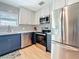 This kitchen features stainless steel appliances, patterned backsplash, and a light wood floor at 1734 Shore Acres Ne Blvd, St Petersburg, FL 33703