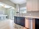 Modern kitchen with tile backsplash, stainless steel appliances, and dark lower cabinets at 1734 Shore Acres Ne Blvd, St Petersburg, FL 33703