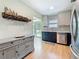 Modern kitchen with tile backsplash, stainless steel appliances, and dark lower cabinets at 1734 Shore Acres Ne Blvd, St Petersburg, FL 33703