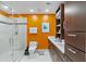 Bright bathroom features a walk-in shower, modern fixtures, and an eye-catching orange accent wall at 175 1St S St # 1003, St Petersburg, FL 33701