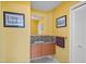 Charming half bathroom features granite countertops, a wood vanity, and stylish decor on yellow painted walls at 175 1St S St # 1003, St Petersburg, FL 33701