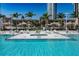 Resort-style pool area with lounge chairs, umbrellas, and lush landscaping at 175 1St S St # 1003, St Petersburg, FL 33701