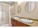 Bathroom featuring granite countertops, double sinks, wood cabinets, and a tiled shower at 2226 Soho Bay Ct, Tampa, FL 33606