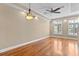 Inviting bedroom featuring hardwood floors, tray ceiling, and abundant natural light from shuttered windows at 2226 Soho Bay Ct, Tampa, FL 33606