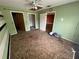 Bedroom featuring a ceiling fan and multiple doorways, with carpet and signs of wear at 3206 Las Brisas Dr, Riverview, FL 33578
