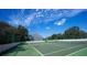 Well-maintained tennis court surrounded by lush greenery and a clear blue sky at 3301 Bayshore Blvd # 2003D, Tampa, FL 33629
