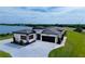 Stunning aerial view of a modern home with a two-car garage and landscaping near the lake at 3610 Gulf City Rd, Ruskin, FL 33570