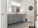 Well-lit bathroom featuring a gray vanity with double sinks and a stylish mirror at 3610 Gulf City Rd, Ruskin, FL 33570