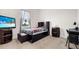 Well-furnished bedroom featuring a sleek entertainment center, a window with a view, and carpeted floor at 3610 Gulf City Rd, Ruskin, FL 33570