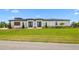 Modern home featuring a manicured lawn, clean lines, contemporary design, and symmetrical landscaping at 3610 Gulf City Rd, Ruskin, FL 33570