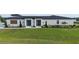 Lush green lawn complements this modern home with its striking double door entrance and sleek exterior design at 3610 Gulf City Rd, Ruskin, FL 33570