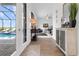 Hallway featuring wood-look tile, cabinet and views of living room and pool at 3610 Gulf City Rd, Ruskin, FL 33570