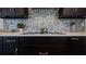 Close up of a modern kitchen featuring a tile backsplash, quartz countertops, and dark wood cabinets at 3610 Gulf City Rd, Ruskin, FL 33570