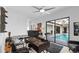 Bright office featuring a ceiling fan, neutral carpet, and an adjacent screened-in pool at 3610 Gulf City Rd, Ruskin, FL 33570