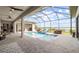 Large screened-in pool with a covered patio, outdoor furniture, and a beautifully paved deck at 3610 Gulf City Rd, Ruskin, FL 33570