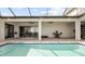 Backyard pool with travertine tile, ceiling fans, lounge chairs, and dining area at 3610 Gulf City Rd, Ruskin, FL 33570