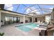Screened-in pool featuring travertine tile, ceiling fans, and lounge chairs at 3610 Gulf City Rd, Ruskin, FL 33570