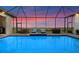Inviting screened-in pool featuring an outdoor lounge area at sunset with comfortable patio furniture at 3610 Gulf City Rd, Ruskin, FL 33570