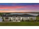 Beautiful rear view of home overlooking the lake and manicured lawn against sunset skies at 3610 Gulf City Rd, Ruskin, FL 33570