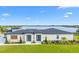 Lakefront home with a pristine lawn and well-maintained landscaping on a sunny day at 3610 Gulf City Rd, Ruskin, FL 33570