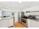 Open kitchen with stainless steel appliances, an adjacent living area, and bright, natural light at 3611 4Th N Ave, St Petersburg, FL 33713