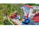Aerial view of backyard with outdoor seating, tropical landscaping and two-story home with red roof at 4151 Sunrise S Dr, St Petersburg, FL 33705