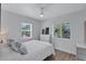 Bright bedroom features crisp white bedding, light-colored floors, and natural light from two windows at 4151 Sunrise S Dr, St Petersburg, FL 33705