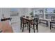 Dining room with a dark wood table, four chairs, bench seating and natural light from windows at 4151 Sunrise S Dr, St Petersburg, FL 33705