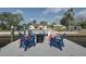 Relaxing dock area with comfortable red and blue chairs arranged around a modern, round fire pit at 4151 Sunrise S Dr, St Petersburg, FL 33705