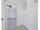 Hallway with light gray floors leading to a white front door, ceiling fan, and light gray walls at 4151 Sunrise S Dr, St Petersburg, FL 33705