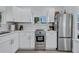 Well-lit kitchen boasts new stainless steel oven, refrigerator, and white cabinetry at 4151 Sunrise S Dr, St Petersburg, FL 33705