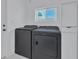 Well-lit laundry room with modern washer and dryer and built-in cabinet at 4151 Sunrise S Dr, St Petersburg, FL 33705