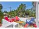 A colorful roof deck with seating and tables offers private outdoor space with tropical landscaping views at 4151 Sunrise S Dr, St Petersburg, FL 33705