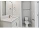 A bathroom boasts a pedestal sink, toilet, and unique patterned flooring, offering style and functionality at 445 31St N Way, St Petersburg, FL 33713