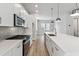 Modern kitchen features white cabinets, quartz countertops, stainless steel appliances, and a large island with pendant lighting at 445 31St N Way, St Petersburg, FL 33713