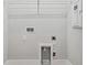 Well-lit laundry room features essential hookups and shelving for convenience and organization at 445 31St N Way, St Petersburg, FL 33713