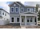 Charming two-story home featuring stone accents, a covered porch, and a classic gray and white color scheme at 5001 21St N Ave, St Petersburg, FL 33710