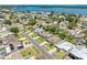 Aerial view of a residential neighborhood with mature trees, and updated homes showcasing metal roofs in a waterfront community at 5731 Denver Ne St, St Petersburg, FL 33703