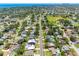 Straight-on aerial view of a neighborhood with mature trees, a clear view of the skyline, and a metal roof home in the foreground at 5731 Denver Ne St, St Petersburg, FL 33703