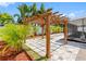 Backyard featuring wooden pergola and landscaping with manicured mulch beds and pavers at 5731 Denver Ne St, St Petersburg, FL 33703