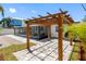 A wooden pergola situated next to a screened lanai sits on a beautiful paver patio with landscaping at 5731 Denver Ne St, St Petersburg, FL 33703
