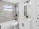 Elegant bathroom with a marble tiled shower/tub and sleek black fixtures at 5731 Denver Ne St, St Petersburg, FL 33703