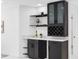 Modern living area with a stylish bar featuring glass cabinets and a wine rack at 5731 Denver Ne St, St Petersburg, FL 33703