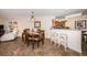 Dining area next to kitchen with wooden table, chandelier and breakfast bar at 6077 Bahia Del Mar Blvd # 123, St Petersburg, FL 33715