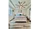 Bright bedroom with a ceiling fan, tray ceiling, and large windows, providing ample natural light at 6293 Bradford Woods Dr, Zephyrhills, FL 33542