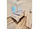 Cozy bedroom with window, complemented by stylish decor and hardwood floors, creating a comfortable retreat at 6293 Bradford Woods Dr, Zephyrhills, FL 33542