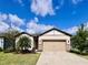 Charming single-story home features a well-manicured lawn and a neutral colored facade with stone accents at 6293 Bradford Woods Dr, Zephyrhills, FL 33542