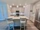 Modern kitchen features an island with a sink and seating, stainless steel appliances, and elegant pendant lighting at 6293 Bradford Woods Dr, Zephyrhills, FL 33542